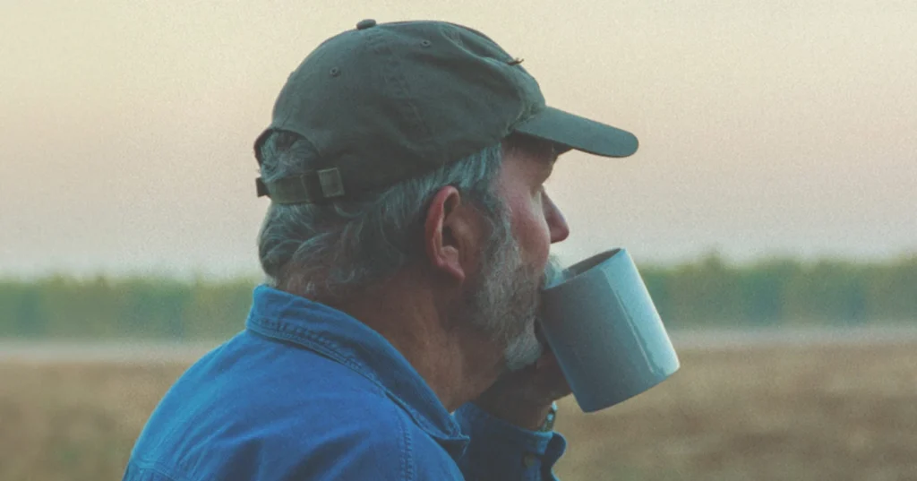 Man drinking a cup of coffee in a field
